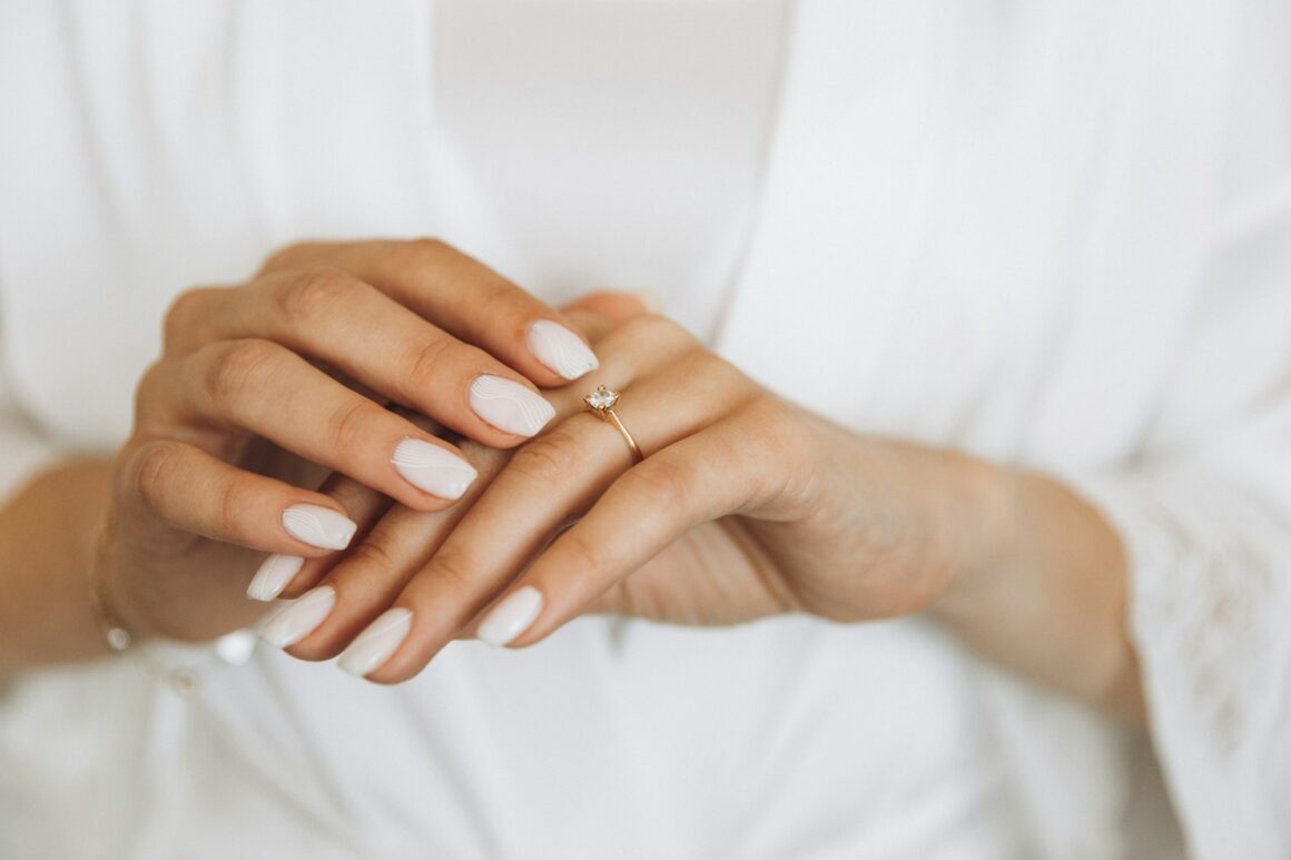 Close-up bride hands touching wedding ring at home