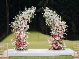 Wedding ceremony on the street on the green lawn.Decor with fresh flowers arches for the ceremony