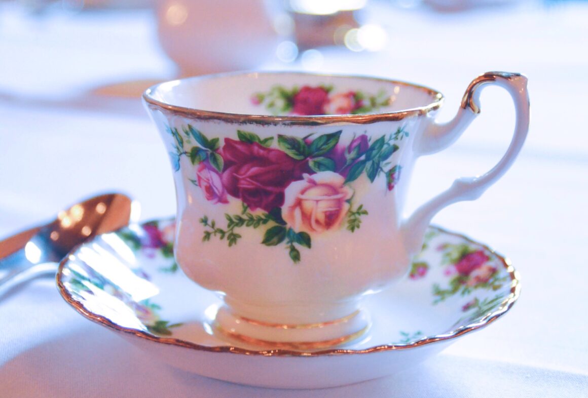 Vintage teacup and saucer with a rose pattern on a table at a restaurant