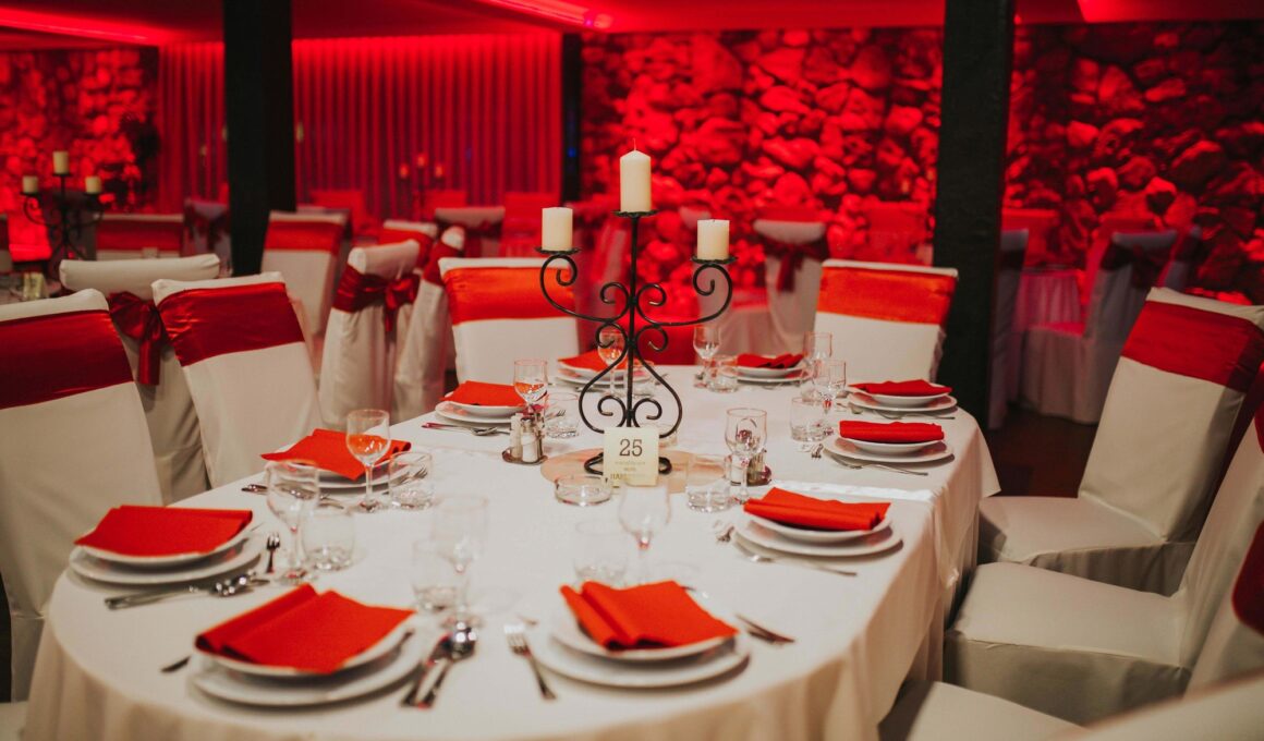 Closeup of prepared tables under red led lights for a wedding celebration in a restaurant