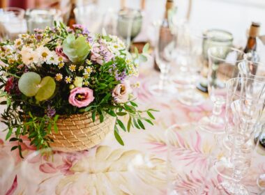 Flowers decorating the centerpieces with luxury cutlery on the tables of a wedding hall.