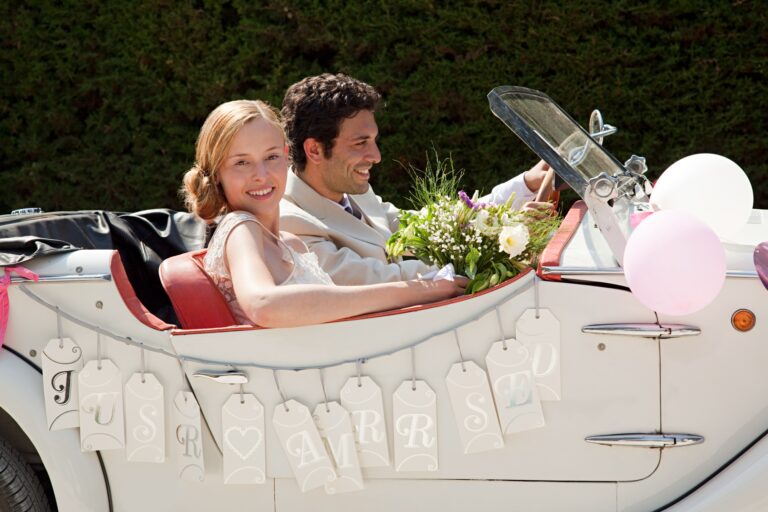 Newlyweds leaving for honeymoon in vintage car