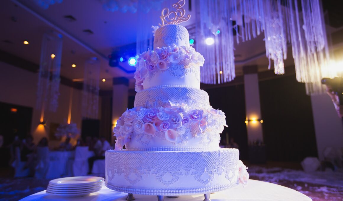 big white wedding cake with pink roses on a white table