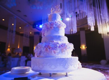 big white wedding cake with pink roses on a white table