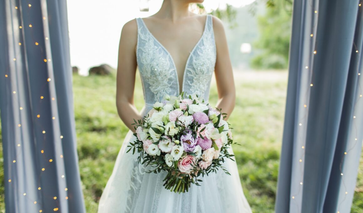 Bride holding in hands small wedding bouquet in pastel colors. Light pink and white roses