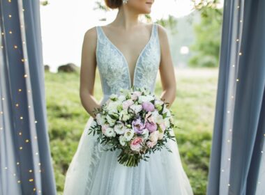 Bride holding in hands small wedding bouquet in pastel colors. Light pink and white roses