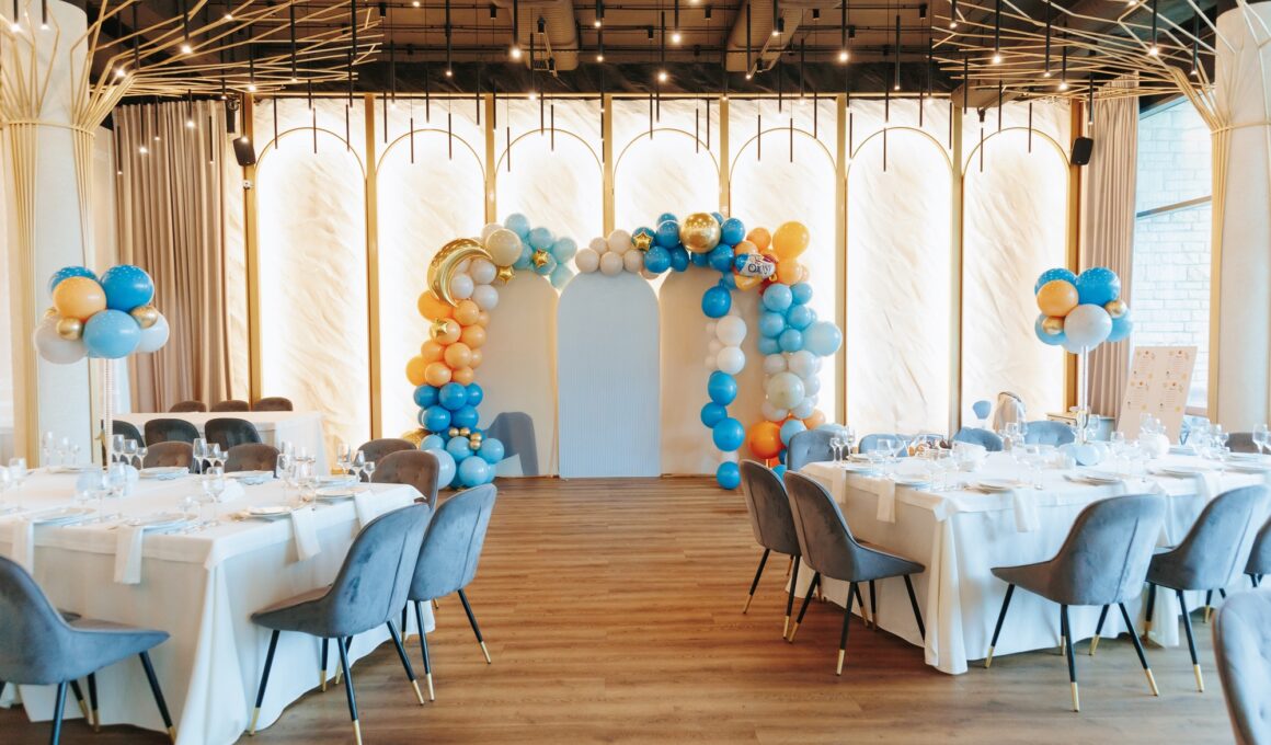 Elegant event venue with balloon arch and stylish table arrangements.