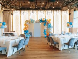 Elegant event venue with balloon arch and stylish table arrangements.