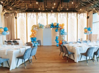 Elegant event venue with balloon arch and stylish table arrangements.