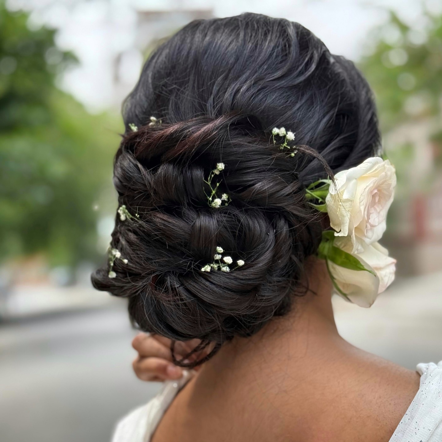 Messy Low Bun with White Rose Accents