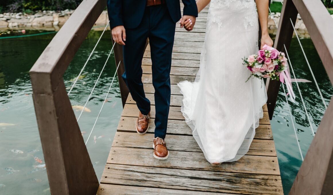 Wedding ceremony near lake. View of the bottom couple newlyweds bride and groom walking along the