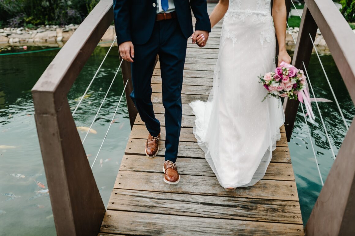 Wedding ceremony near lake. View of the bottom couple newlyweds bride and groom walking along the