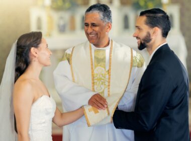 Wedding, priest and couple holding hands in church for a christian marriage oath and faithful commi