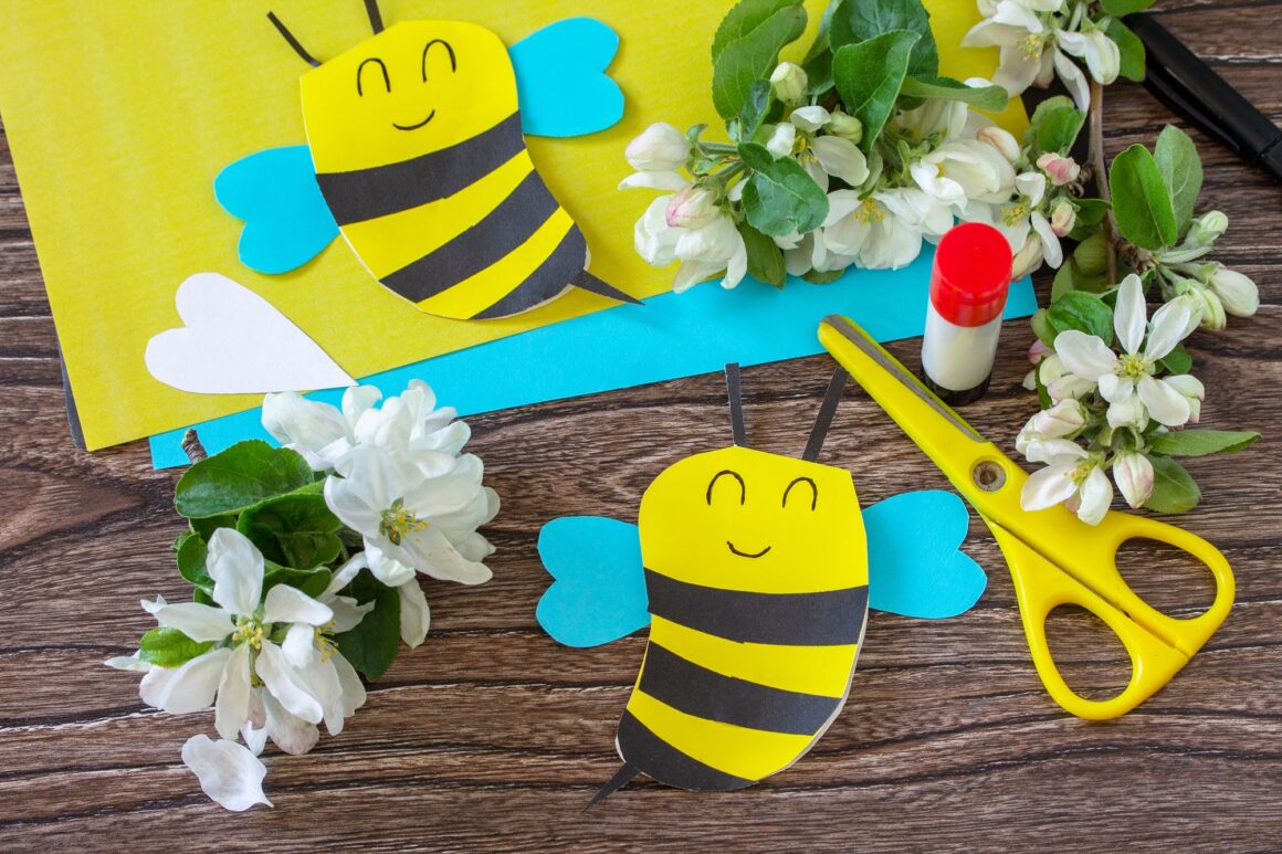 Mother's day greeting card gift - bee with spring apple tree flowers on a wooden table.