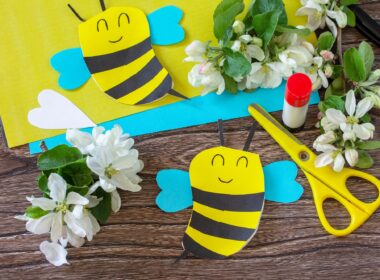 Mother's day greeting card gift - bee with spring apple tree flowers on a wooden table.