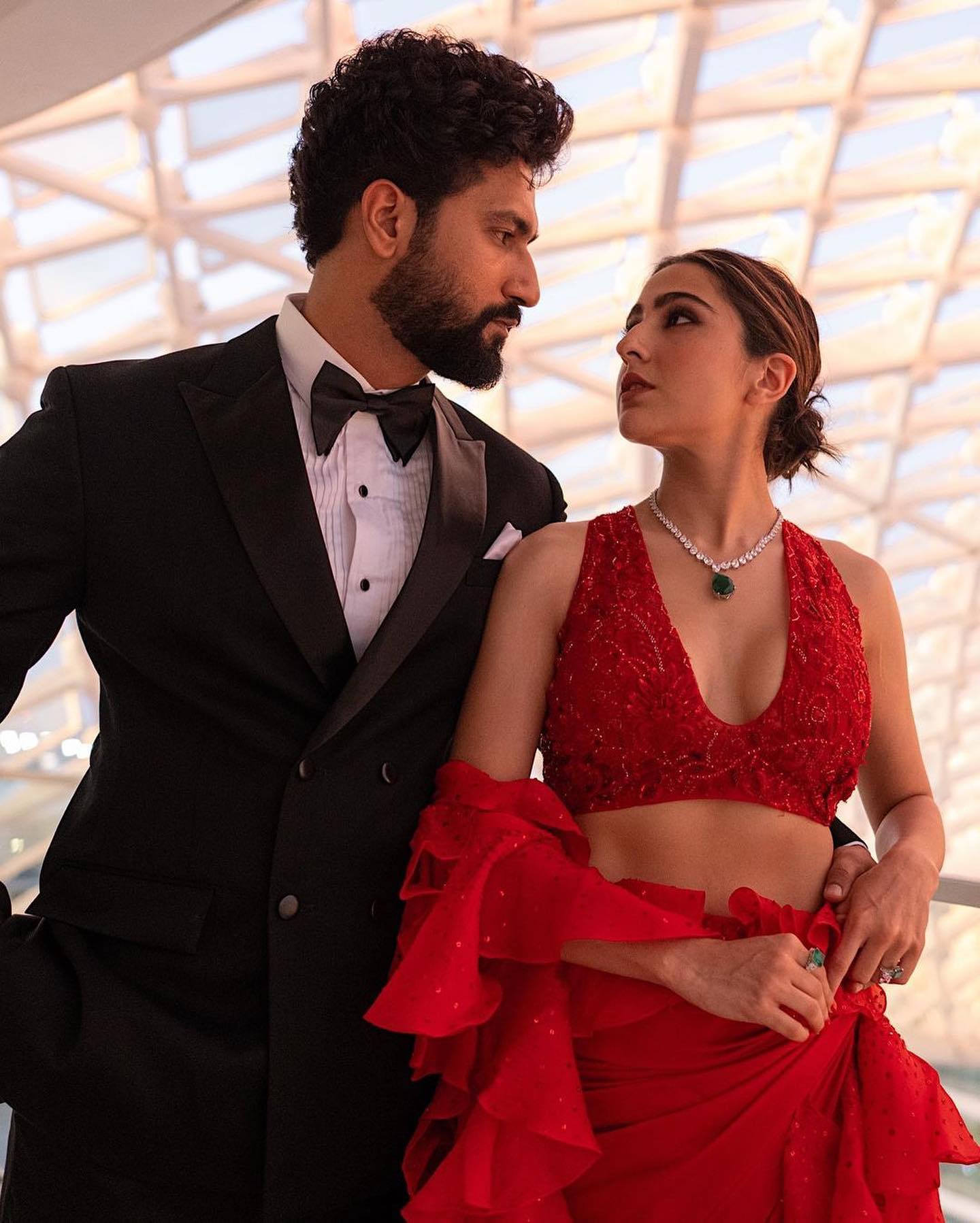 Red Dress paired with black suit for a power couple look