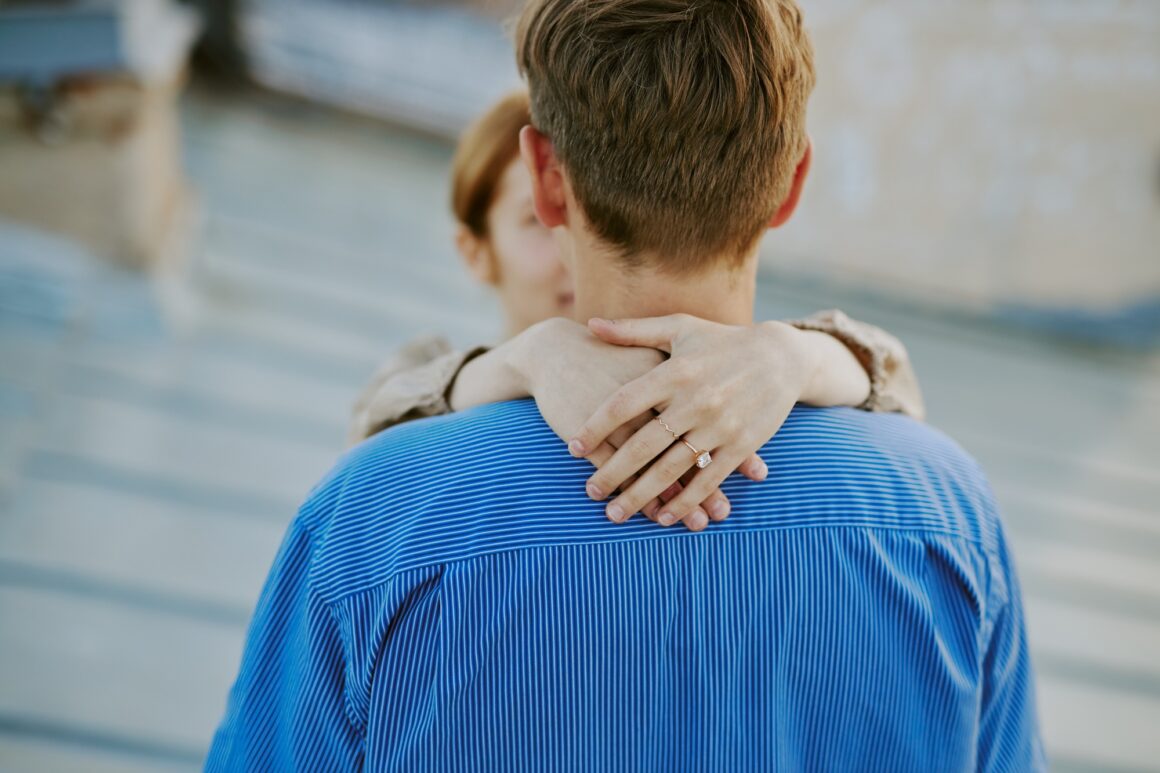 Couple Embracing with Emphasis on Engagement Ring