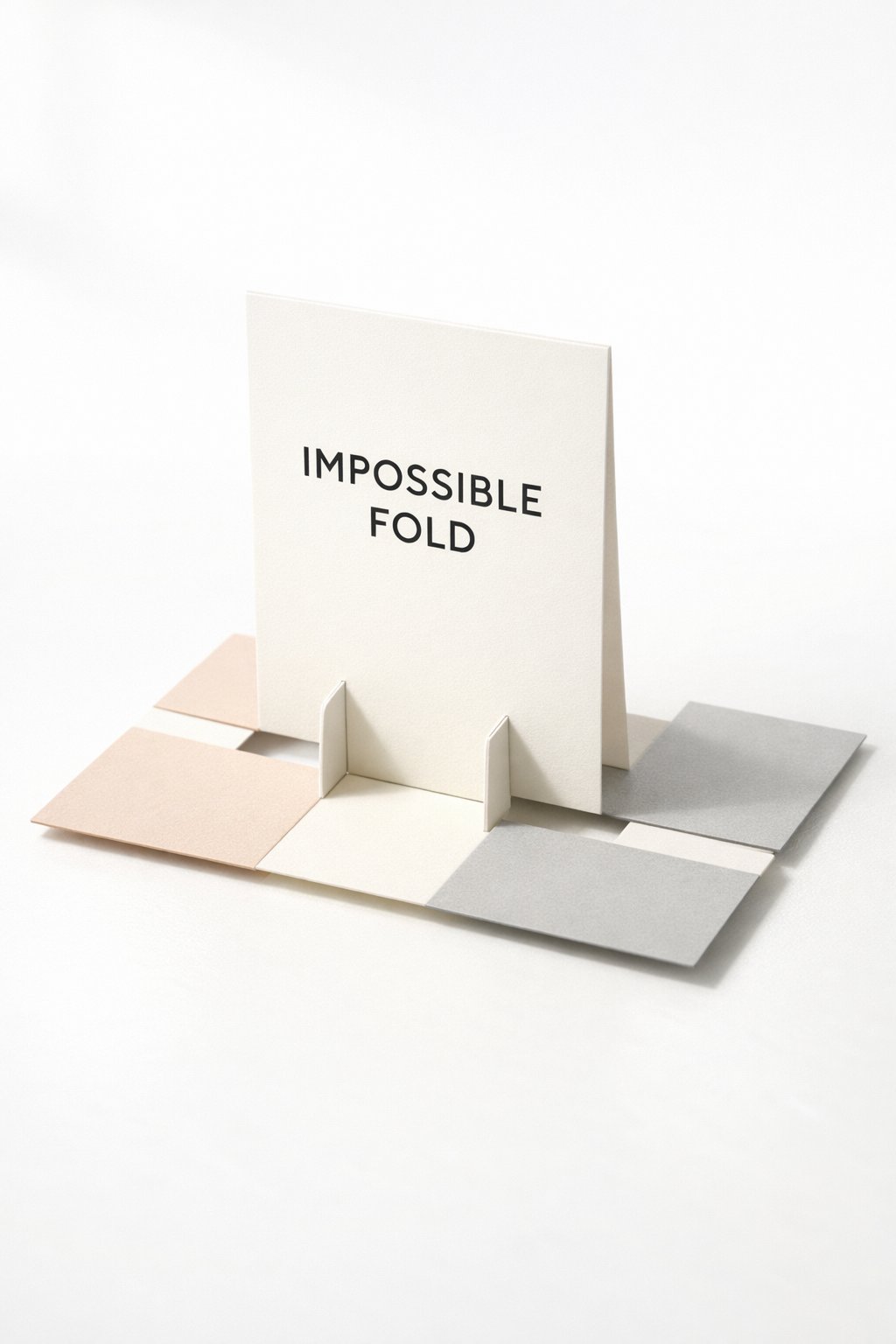 A realistic photo of an Impossible Fold card from a 45-degree angle. The card seems to defy logic with its upright center and flat base. The design is clean and "scandi-style" with neutral tones and black typography. The image is bright and airy.