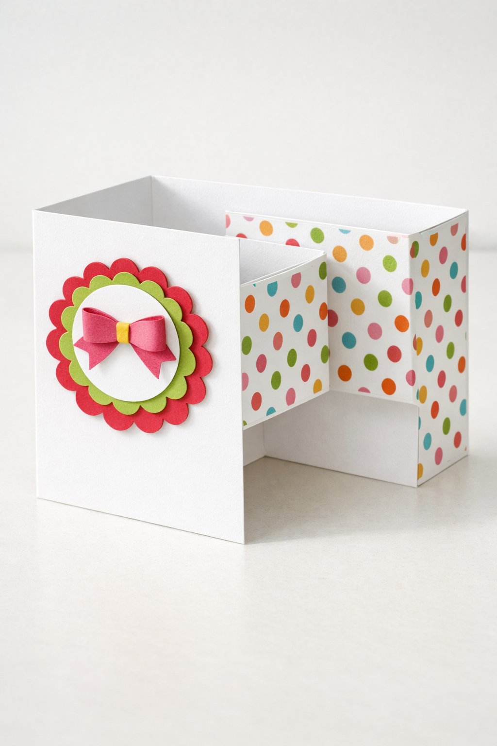 Ultra realistic product photo of a handmade double Z fold card, shown partially open to display the double Z fold structure clearly, bright white base with colorful polka dot patterned paper on panels, a layered scalloped circle on the front panel with a small bow made from cardstock, crisp folds, matte cardstock texture, photographed on a bright neutral tabletop with soft natural light, minimal props, no hands, no text, no watermark, sharp focus, high detail.