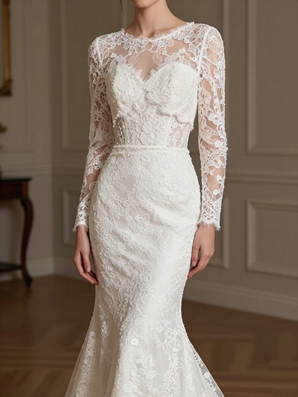 Image Prompt: A high-fashion bridal editorial image of a fitted mermaid wedding dress paired with a cropped lace bolero. Show the bride from the neck down or in a back three-quarter pose with the face hidden. The bolero has long fitted lace sleeves and a soft cropped shape that defines the waist, layered over a sleek mermaid silhouette. Set in a classic indoor wedding venue with elegant lighting, realistic lace detail, editorial bridal styling, no visible face, no text, no watermark. (no watermarks on images)
