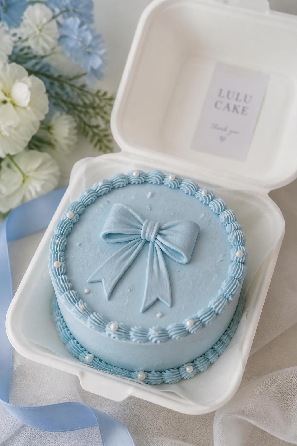 Image Prompt:
A beautiful blue bow bento cake inside an open white bento box, pale blue frosting, central buttercream bow design, tiny pearl sprinkles, delicate piped border, sweet coquette bakery styling, soft pastel backdrop, realistic DSLR dessert photography, no people, no hands, no faces, (no watermarks on images)