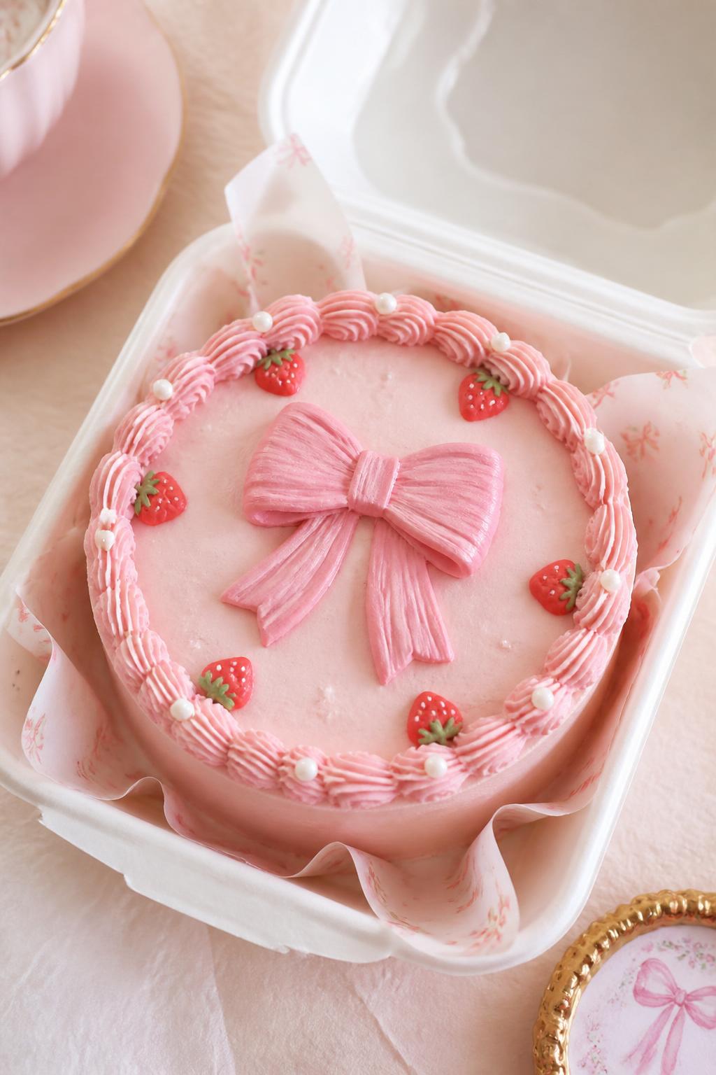 Image Prompt:
A cute strawberry bow bento cake inside an open white bento box, pale strawberry pink frosting, central buttercream bow design, tiny pearl sprinkles, small strawberry details around the edges, delicate piped border, sweet coquette bakery styling, soft pastel backdrop, realistic DSLR dessert photography, no people, no hands, no faces, no watermarks on images