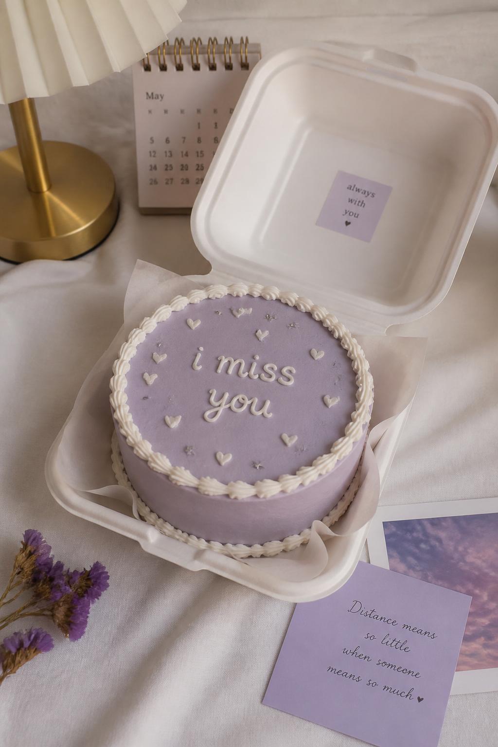 Image Prompt:
A soft romantic bento cake for boyfriend with pale lavender buttercream frosting, smooth finish, white piped border, icing text reading “i miss you,” tiny silver star sprinkles and small white hearts, placed in an open bento cake box, gentle long-distance love theme, soft bedroom desk styling without people, realistic DSLR dessert photography, no hands, no faces, no watermarks on images