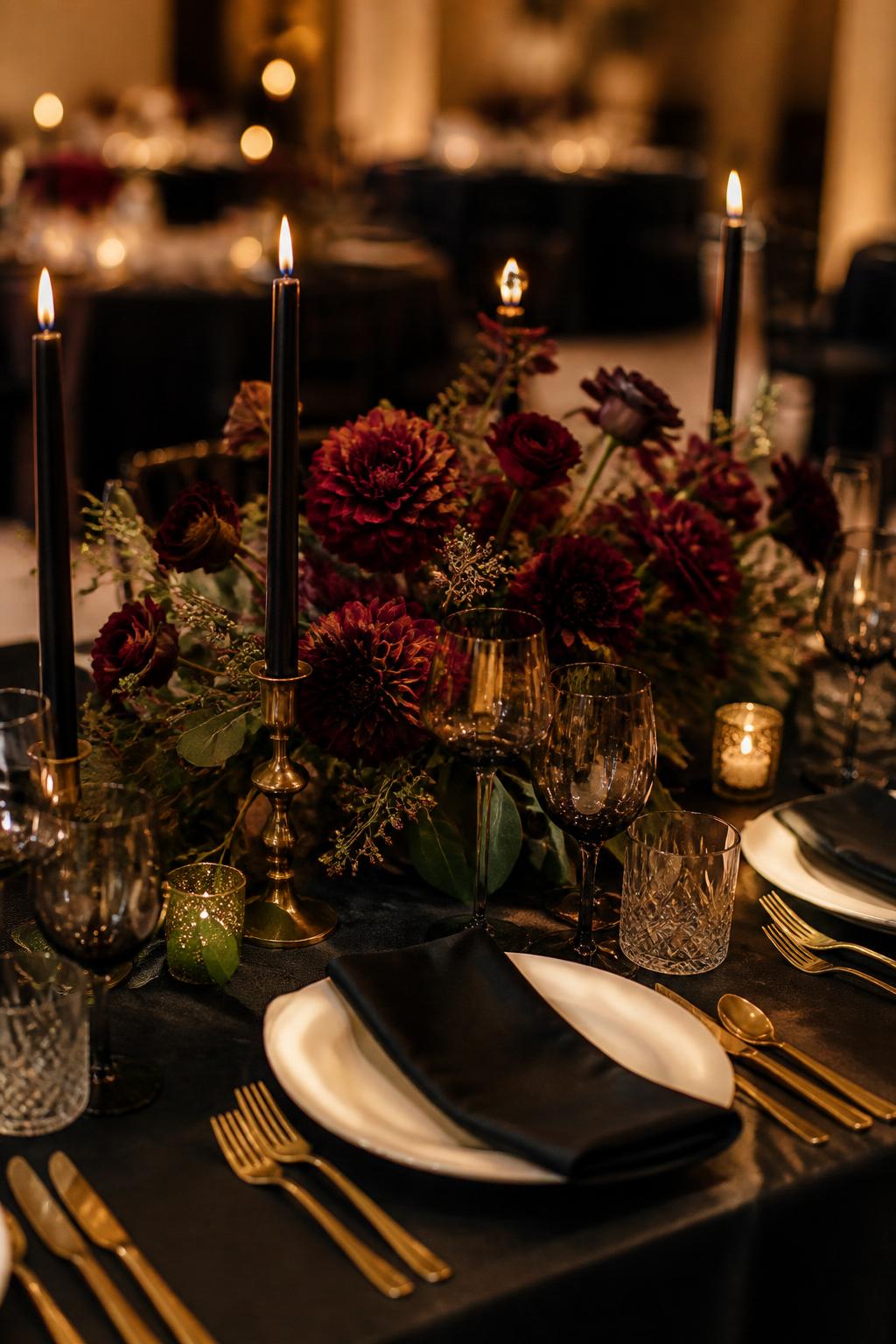 Image Prompt:
A dramatic wedding reception table styled with burgundy dahlias, deep red roses, plum ranunculus, dark greenery, black taper candles, gold flatware, ivory plates, smoky glassware, and warm low lighting. Elegant evening wedding venue, no visible faces, no text, no watermark, high-end DSLR wedding photography, (no watermarks on images)