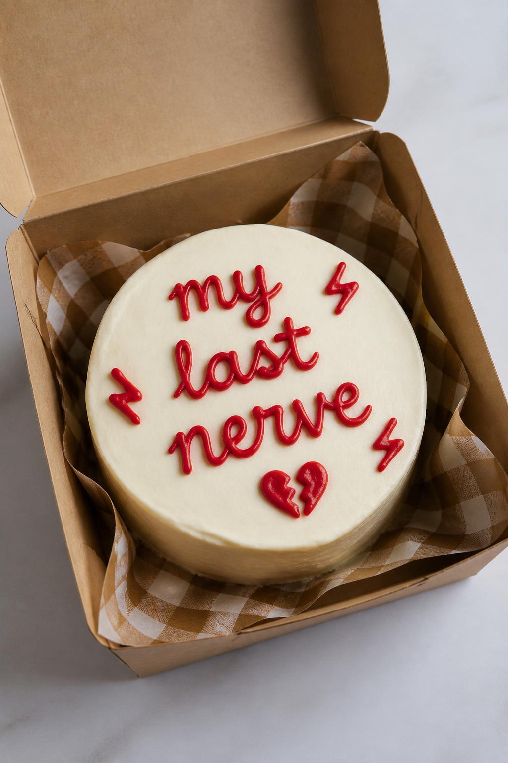 Image Prompt:
A funny bento cake inside an open kraft bento box, smooth cream frosting, bold red handwritten icing text reading “my last nerve,” tiny broken heart doodle and small lightning accents, playful dramatic styling, realistic editorial bakery photography, no people, no hands, no faces, no watermarks on images