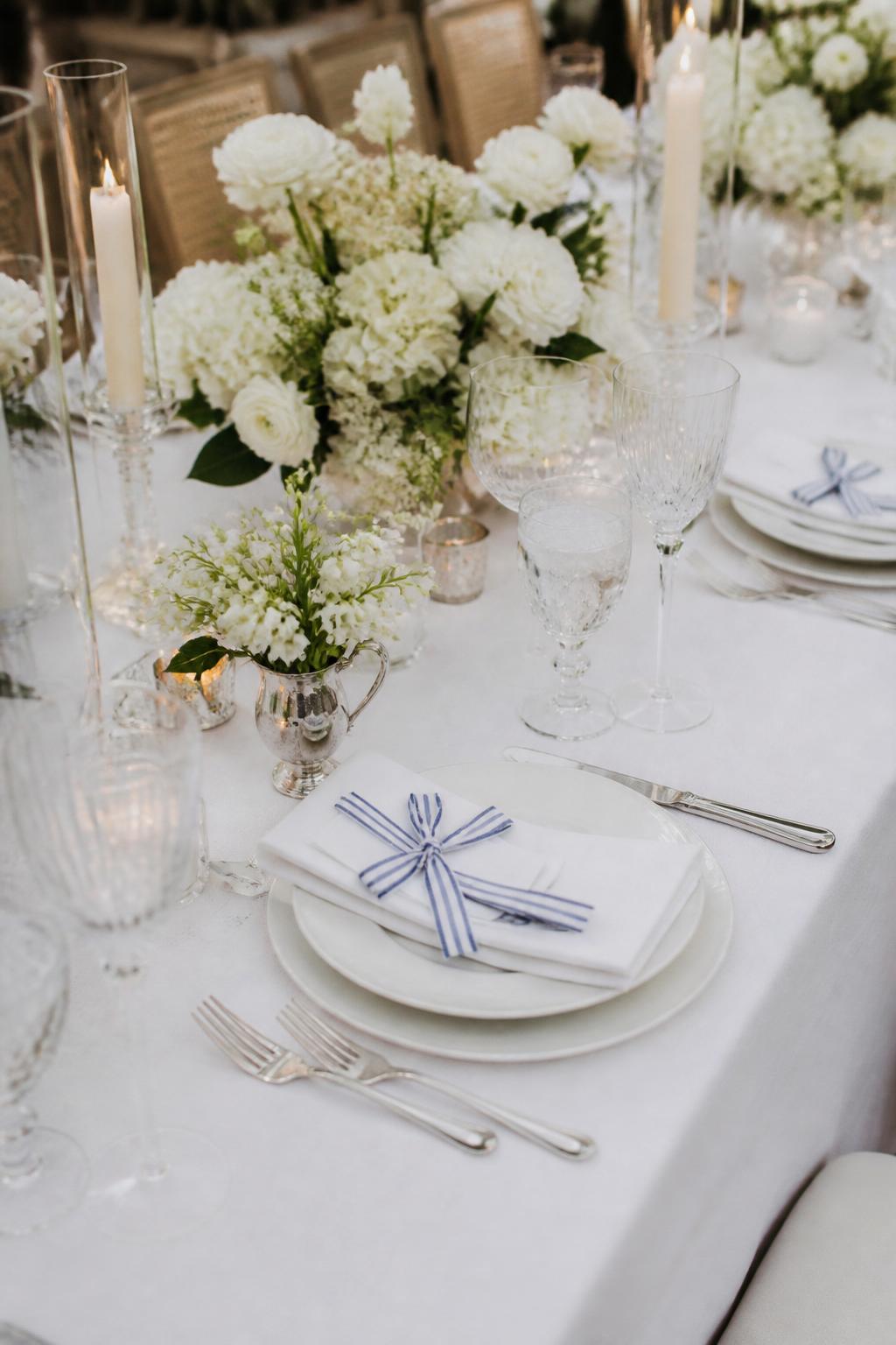 Image Prompt:
A chic country club wedding table styled with white linen, white flowers, crystal glasses, polished flatware, and subtle striped ribbon details tied around napkins or small place cards. Use navy, soft blue, or green ribbon tones. No visible faces, no text, no watermark, realistic DSLR editorial wedding photography, (no watermarks on images)