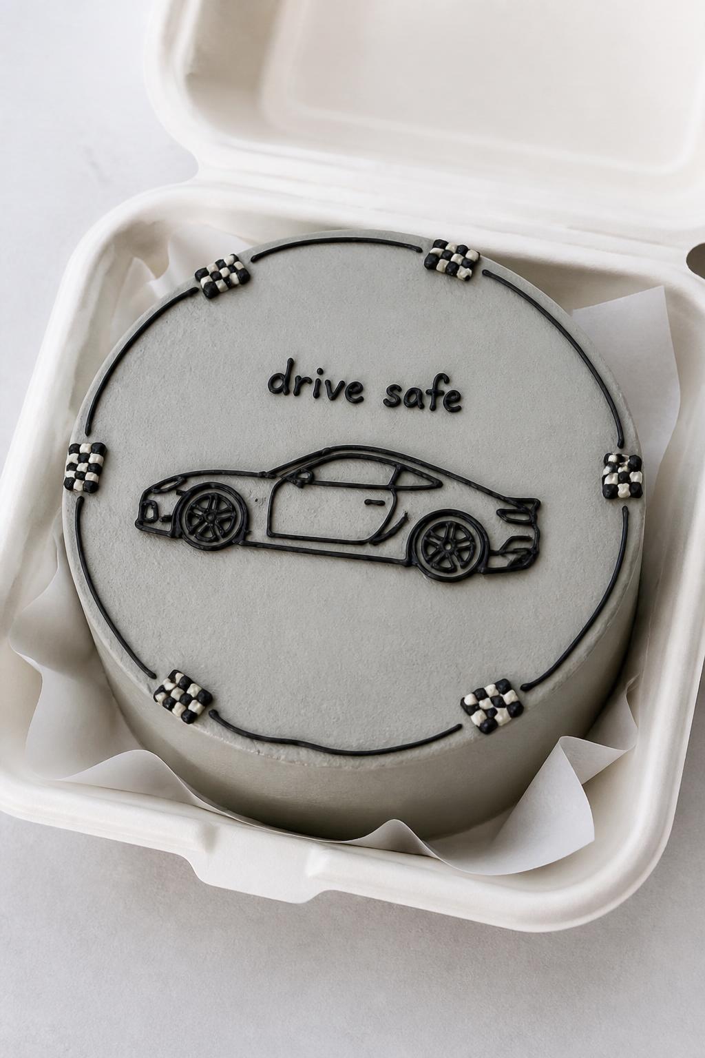 Image Prompt:
A car lover bento cake for men in an open white bento cake box, smooth light gray frosting, simple black icing outline of a sports car on top, tiny checkered flag details on the border, short text reading “drive safe,” clean modern styling, realistic close-up bakery photography, no people, no hands, no faces, no watermarks on images