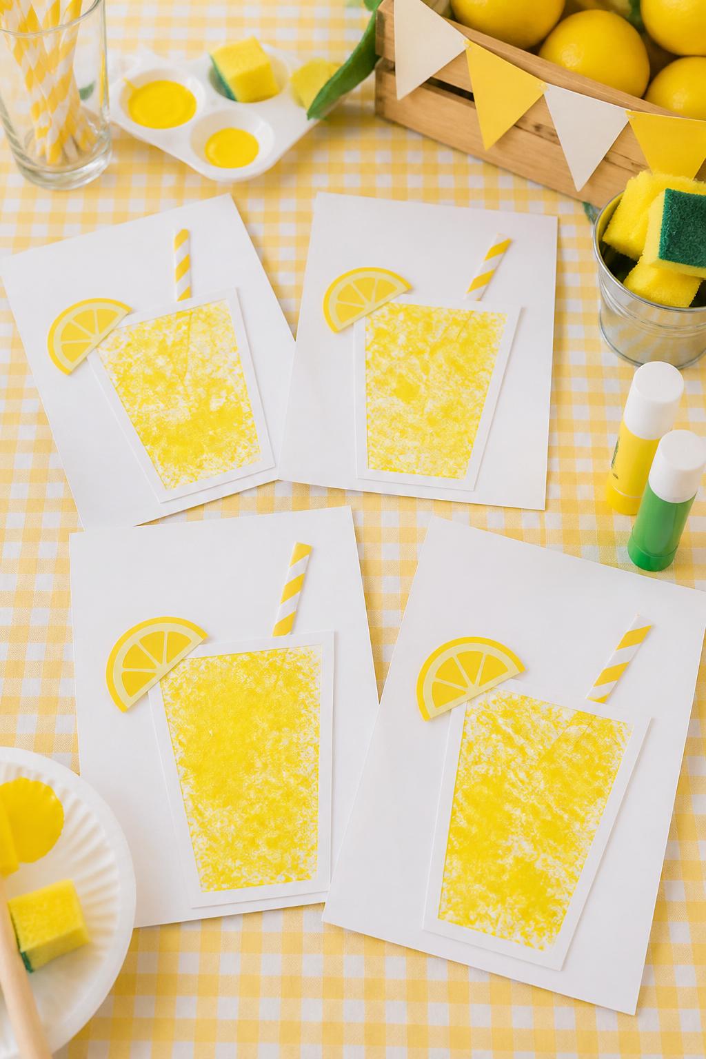 Detailed Image Prompt:
A sunny summer daycare craft photo showing sponge-stamped lemonade cups on cardstock, paper cup shapes filled with yellow sponge paint, small paper lemon slices and straw cutouts attached, washable paint, sponge pieces, and glue sticks nearby, fresh lemonade stand theme, bright clean table, no people, no faces, no readable text, no watermark on images.
