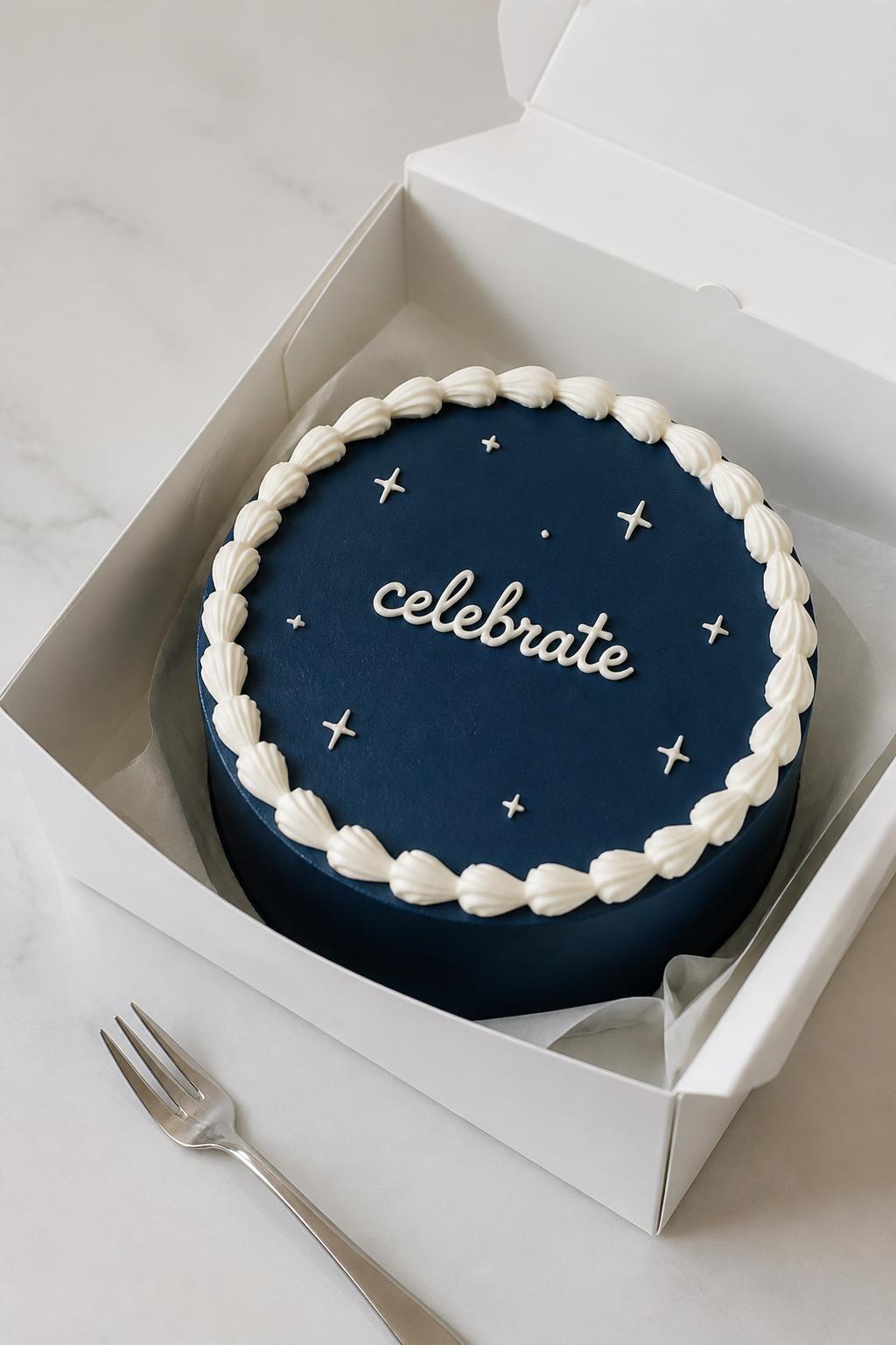Image Prompt:
A stylish navy blue bento cake inside an open white cake box, smooth deep navy frosting, crisp white piped border, elegant short icing text reading “celebrate,” tiny star accents, sleek modern dessert styling, silver mini fork nearby, soft studio light, realistic editorial bakery photography, no people, no hands, no faces, (no watermarks on images)