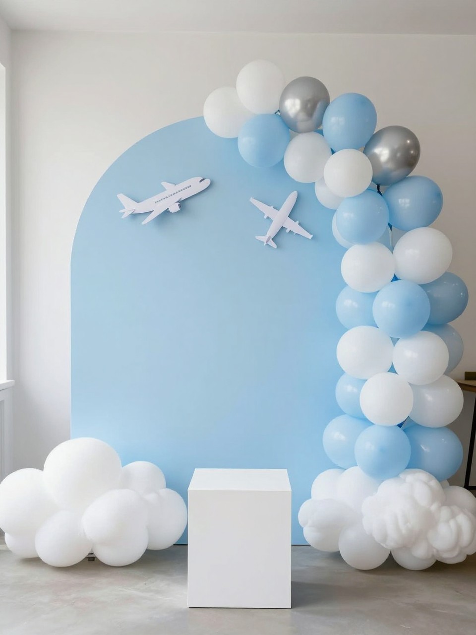 Image Prompt:
A single realistic photo of a farewell backdrop with a large sky-blue curved panel, fluffy white faux cloud props arranged at the base, a small airplane cutout detail attached near the top, balloon garland in white, pale blue, and silver, a white plinth in front, bright airy indoor party setting, no people, no faces, realistic modern party photography, no text, no watermark.