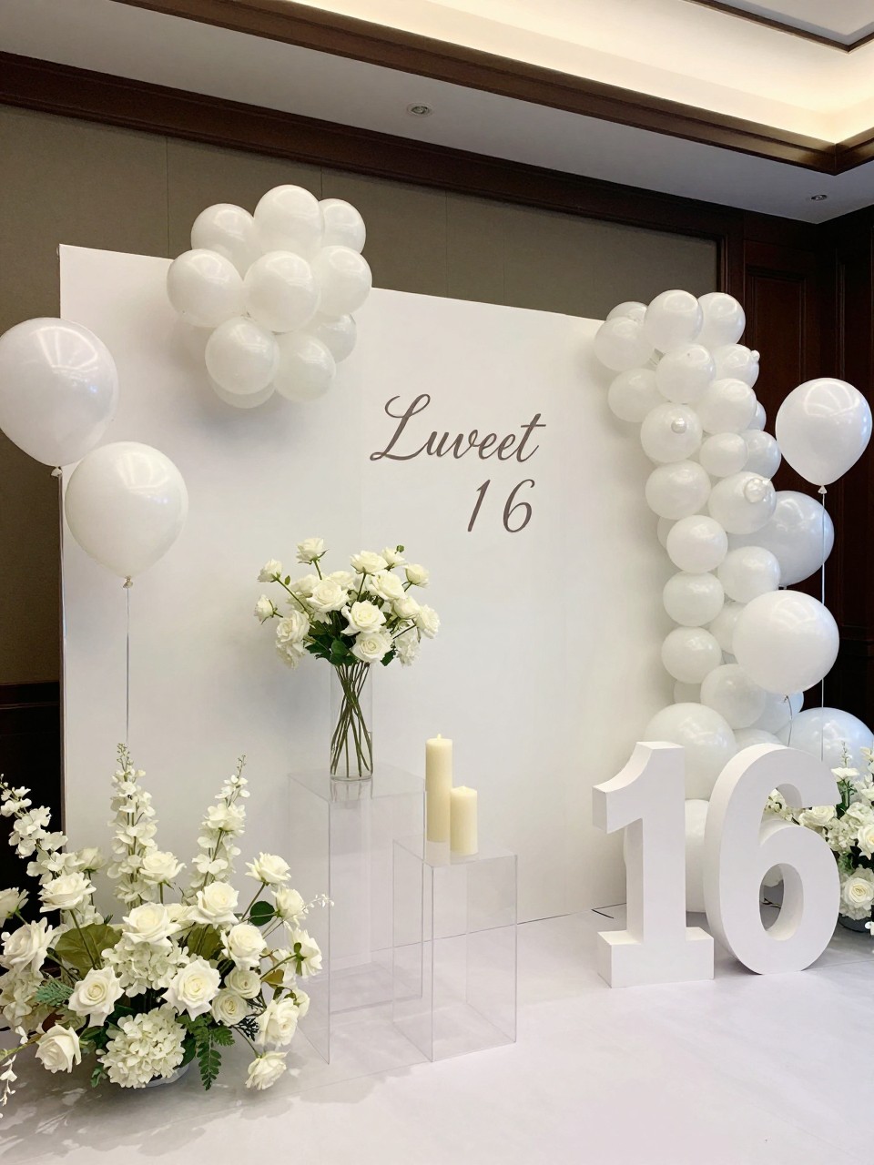 Image Prompt:
A single realistic photo of a luxurious all-white Sweet 16 party backdrop with white curved panels, pearl white balloons, white roses and hydrangeas, clear acrylic plinths, candle-style decor, a white number 16 prop, elegant indoor event space, no people, no faces, soft diffused lighting, realistic upscale party photography, no text, no watermark.